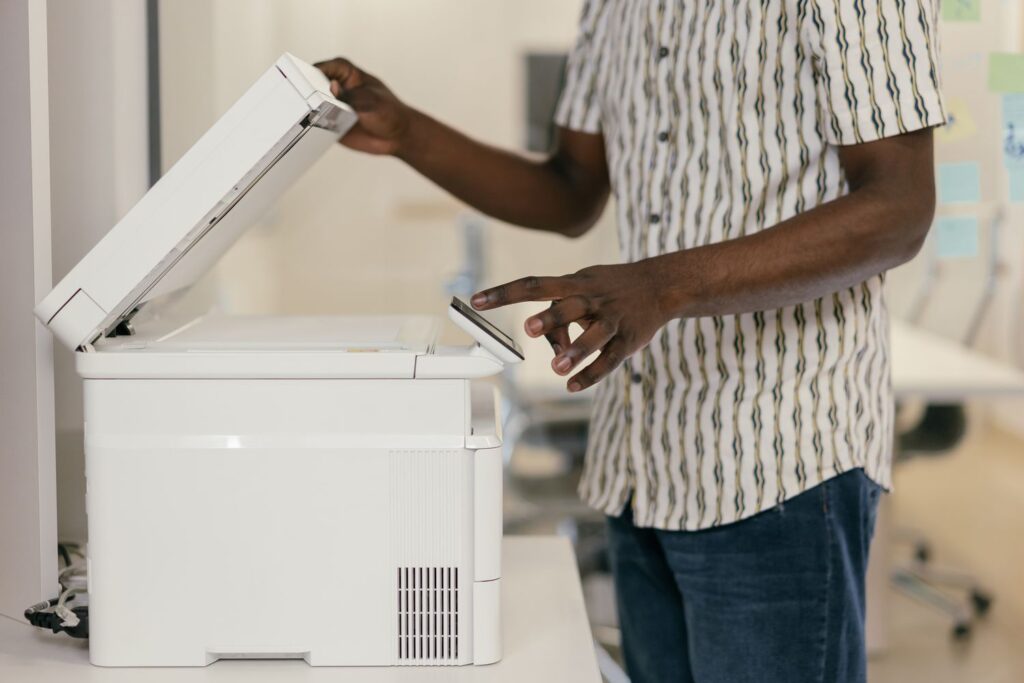 Person scanning a printed document, illustrating OCR software converting paper documents to digital text